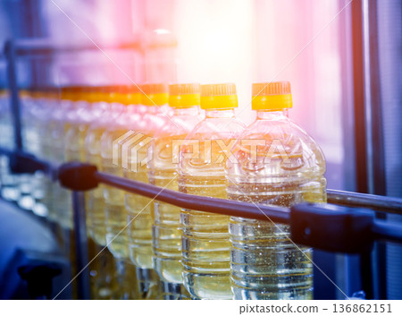 Bottling line of sunflower oil in bottles. Vegetable oil production plant Bottling line of sunflower oil in bottles. Vegetable oil production plant 136862151