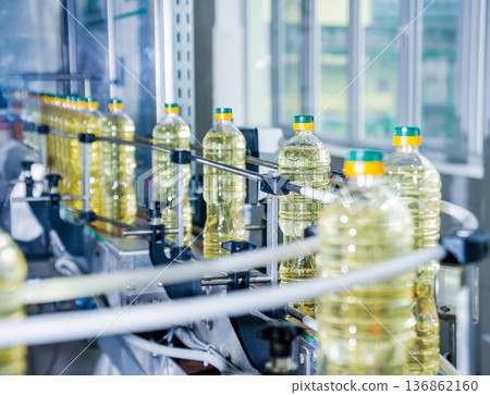 Bottling line of sunflower oil in bottles. Vegetable oil production plant Bottling line of sunflower oil in bottles. Vegetable oil production plant 136862160
