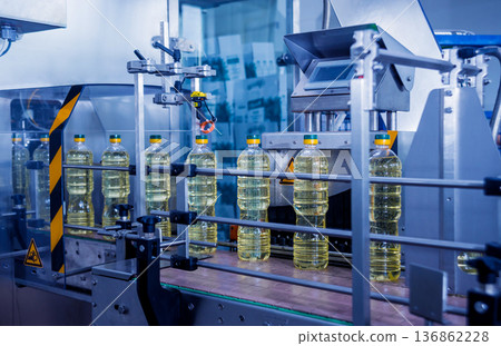 Bottling line of sunflower oil in bottles. Vegetable oil production plant. Bottling line of sunflower oil in bottles. Vegetable oil production plant. 136862228