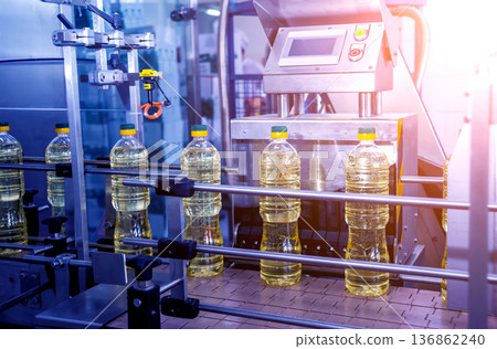Bottling line of sunflower oil in bottles. Vegetable oil production plant. Bottling line of sunflower oil in bottles. Vegetable oil production plant. 136862240