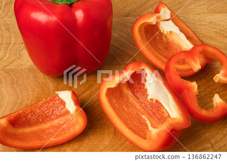Sweet pepper whole and slices on a wooden board Sweet pepper whole and slices on a wooden board 136862247