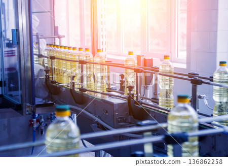 Bottling line of sunflower oil in bottles. Vegetable oil production plant. Bottling line of sunflower oil in bottles. Vegetable oil production plant. 136862258