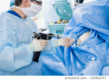 Arthroscope surgery. Orthopedic surgeons in teamwork in the operating room Arthroscope surgery. Orthopedic surgeons in teamwork in the operating room 136862457