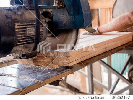 Modern sawmill. A carpenter works on woodworking the machine tool. Modern sawmill. A carpenter works on woodworking the machine tool. 136862467