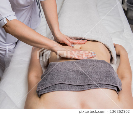 Beautiful young woman enjoying massage in spa salon. Cosmetology Beautiful young woman enjoying massage in spa salon. Cosmetology 136862502