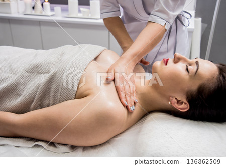 Beautiful young woman enjoying massage in spa salon. Cosmetology Beautiful young woman enjoying massage in spa salon. Cosmetology 136862509