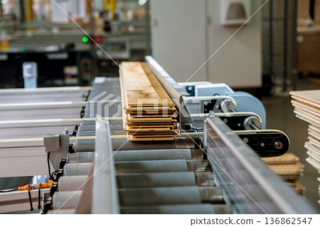 Production line of the wooden floor factory. CNC automatic woodworking machine. Production line of the wooden floor factory. CNC automatic woodworking machine. 136862547