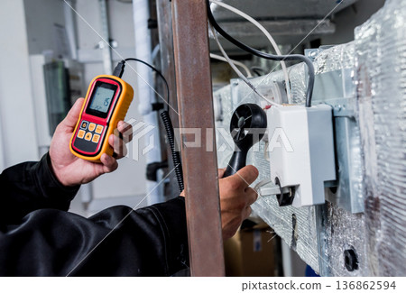 Technician use hand-held anemometer measuring air flowing measurement 136862594
