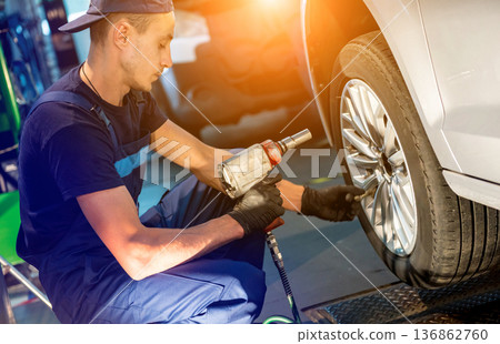 Professional car mechanic working with in auto repair service. Repair of wheels 136862760