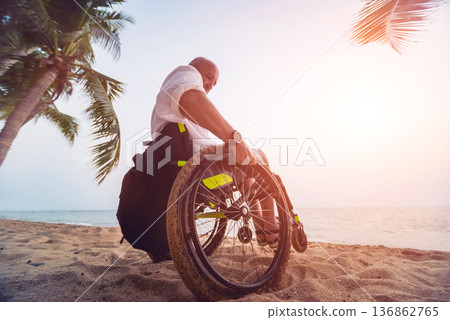 Disabled man in a wheelchair on the beach. 136862765