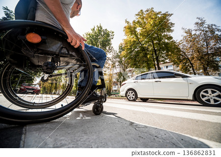 Handicapped man in wheelchair crossing street road 136862831