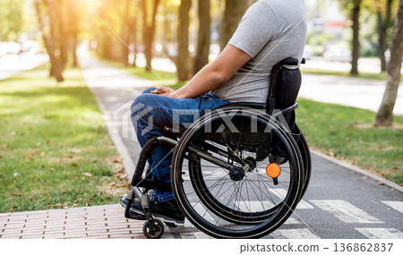Handicapped man in wheelchair preparing to cross the road on pedestrian crossing Handicapped man in wheelchair preparing to cross the road on pedestrian crossing 136862837