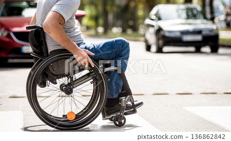 Handicapped man in wheelchair crossing street road 136862842