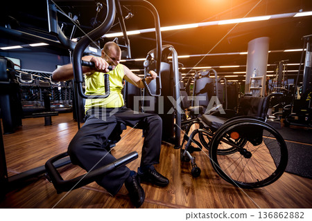 Disabled man training in the gym of rehabilitation center Disabled man training in the gym of rehabilitation center 136862882