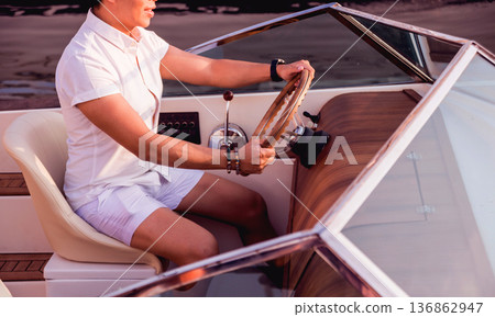 Young man on sailing yacht. Hands hold steering wheel Young man on sailing yacht. Hands hold steering wheel 136862947