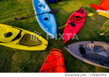 Group of canoes and kayaks on a green grass Group of canoes and kayaks on a green grass 136862956