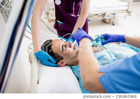 Doctors give resuscitation to a male patient in the emergency room. 136862968