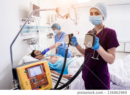 Doctors give resuscitation to a male patient in the emergency room. 136862969