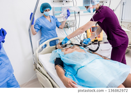 Doctors give resuscitation to a male patient in the emergency room. 136862972