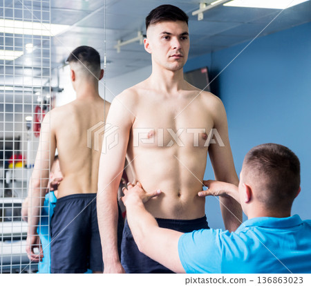Physiotherapist working with young male patient in the rehabilitation center Physiotherapist working with young male patient in the rehabilitation center 136863023
