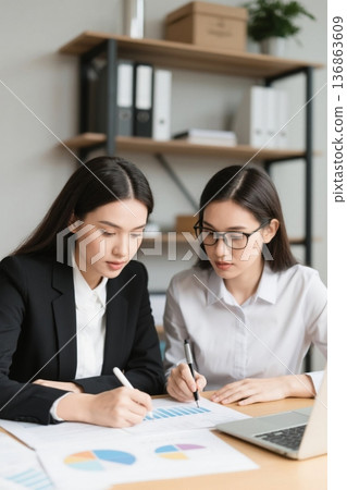 两位年轻女性在办公室认真工作 136863609