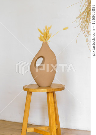 Minimal natural decor, ceramic vases and dry branches on rustic white plaster wall background 136863885