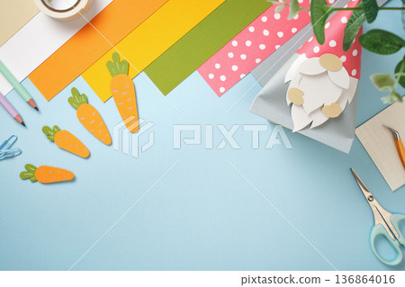 Easter paper crafts with a gnome bunny, carrots, and colorful stationery on a blue background. Spring DIY project. Copyspace. Easter paper crafts with a gnome bunny, carrots, and colorful stationery on a blue background. Spring DIY project. Copyspace. 136864016