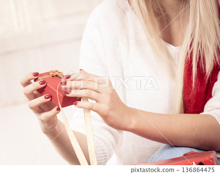 Woman opening christmas presents Woman opening christmas presents 136864475