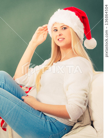 Woman in Santa hat thinking about Christmas Woman in Santa hat thinking about Christmas 136864504