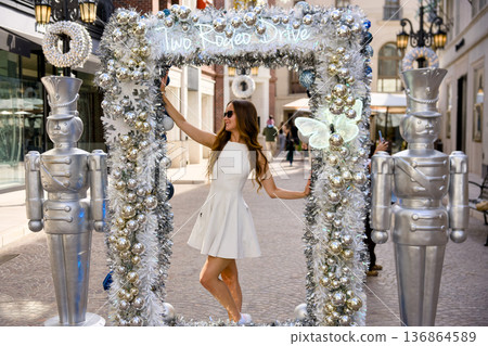 Woman posing in silver holiday arch on Rodeo Drive Beverly Hills Woman posing in silver holiday arch on Rodeo Drive Beverly Hills 136864589