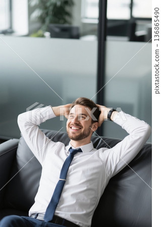 A relaxed businessman leans back on the sofa to rest. A relaxed businessman leans back on the sofa to rest. 136865490