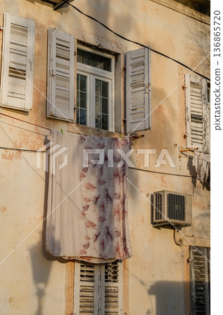 Vertical View of House with Laundry Hanging Outside 136865720