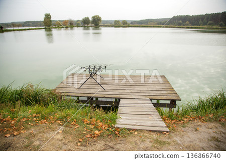 Fishing setup on wooden lake dock 136866740