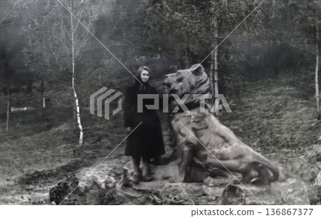 A vintage portrait of a beautiful young girl near a lion statue in Kislovodsk. Retro photo, 1958. A vintage portrait of a beautiful young girl near a lion statue in Kislovodsk. Retro photo, 1958. 136867377