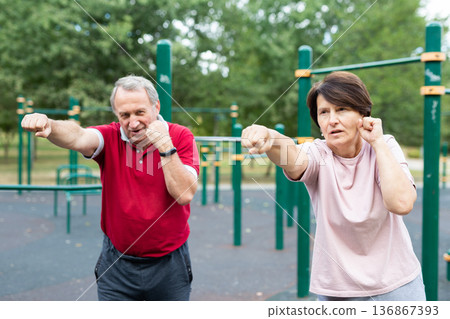 Sports pensioners are engaged in martial art on the sports ground in open air 136867393