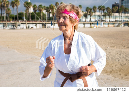 Mature woman running on beach Mature woman running on beach 136867412