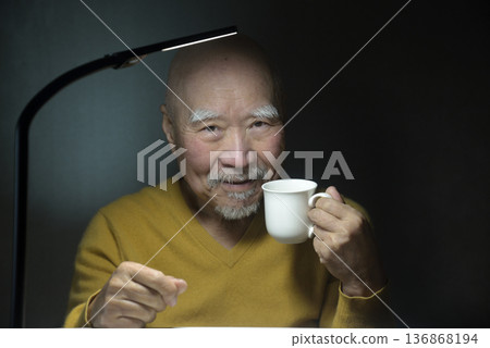 An elderly man relaxing with a hot drink An elderly man relaxing with a hot drink 136868194
