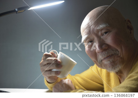 An elderly man relaxing with a hot drink An elderly man relaxing with a hot drink 136868197