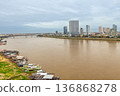 River cruise boats moored along Tonle Sap River with modern skyline in background, Phnom Penh, Cambodia 136868278