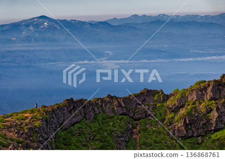 Morning hikers walking along the outer rim of Mt. Chokai and Mt. Gassan and the Asahi mountain range Morning hikers walking along the outer rim of Mt. Chokai and Mt. Gassan and the Asahi mountain range 136868761