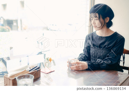A Japanese woman in her 30s looking out the window at a cafe A Japanese woman in her 30s looking out the window at a cafe 136869134