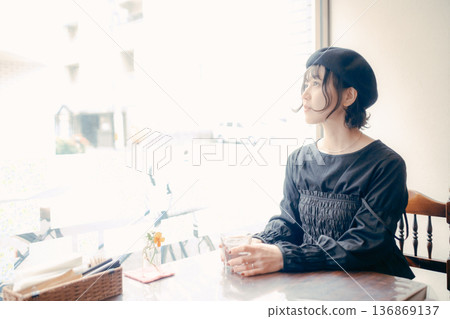 一位三十多歲的日本女性正望著窗外的咖啡館。 136869137