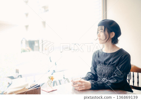 A Japanese woman in her 30s looking out the window at a cafe 136869139