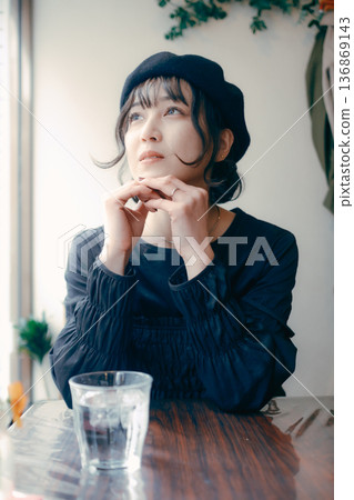 A Japanese woman in her 30s looking out the window at a cafe A Japanese woman in her 30s looking out the window at a cafe 136869143