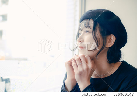 一位三十多歲的日本女性正望著窗外的咖啡館。 一位三十多歲的日本女性正望著窗外的咖啡館。 136869148