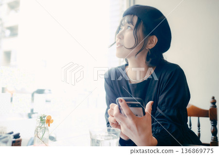一位三十多歲的日本女性在咖啡館操作智慧型手機 一位三十多歲的日本女性在咖啡館操作智慧型手機 136869775