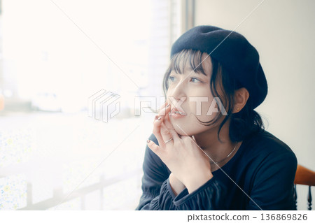 一位三十多歲的日本女性正望著窗外的咖啡館。 一位三十多歲的日本女性正望著窗外的咖啡館。 136869826