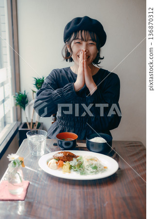 一位三十多歲的日本女性在享用漢堡牛排套餐前說“itadakimasu”(我開動了)。 一位三十多歲的日本女性在享用漢堡牛排套餐前說“itadakimasu”(我開動了)。 136870312