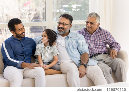 Multi generational Indian family talking seated on sofa Multi generational Indian family talking seated on sofa 136870510