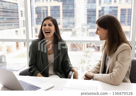 Businesswomen laughing, enjoy friendly work relations, having fun during break 136870526